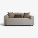 A modern low-profile loveseat sofa upholstered in light gray textured fabric, styled with three throw pillows in brown and taupe, set against a plain white background.