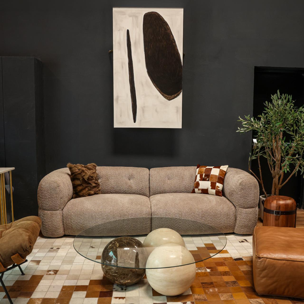 Modern living room with a gray sectional sofa, abstract art, and decorative items.