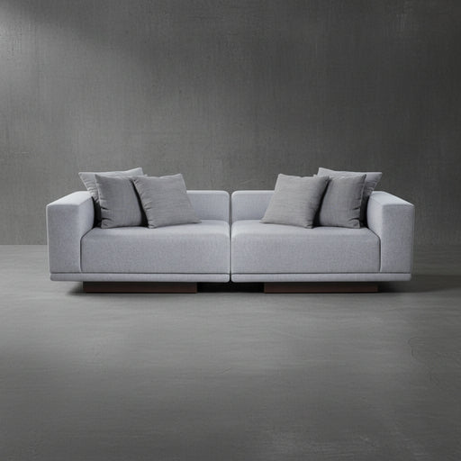 Gray sofa with cushions on a gray floor and wall