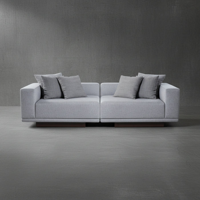 Gray sofa with cushions on a gray floor and wall