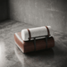 Modern brown and white cushion on a concrete floor with a gray wall background