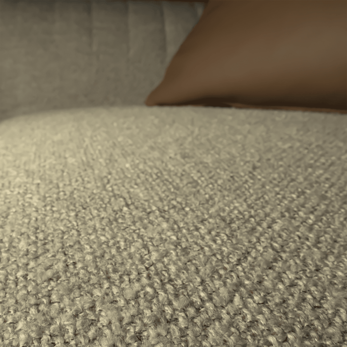 Close-up of a textured beige fabric surface with a brown pillow.