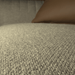 Close-up of a textured beige fabric surface with a brown pillow.