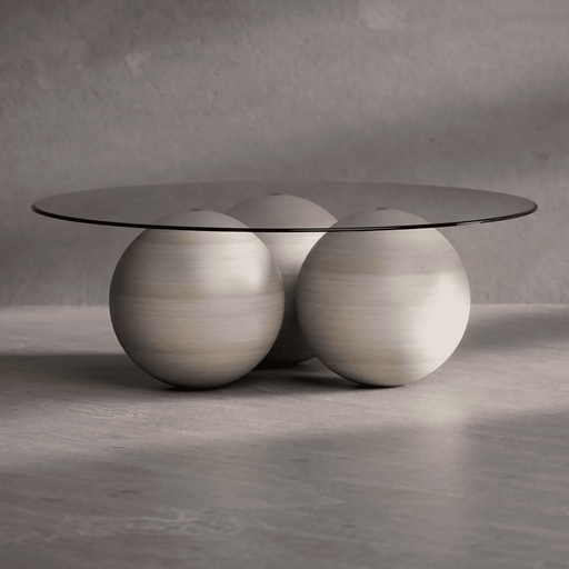 Modern coffee table with glass top and spherical wooden bases on a gray background