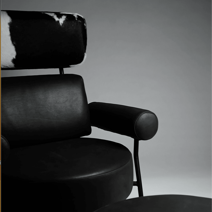 Black leather armchair with cowhide backrest on a gray background