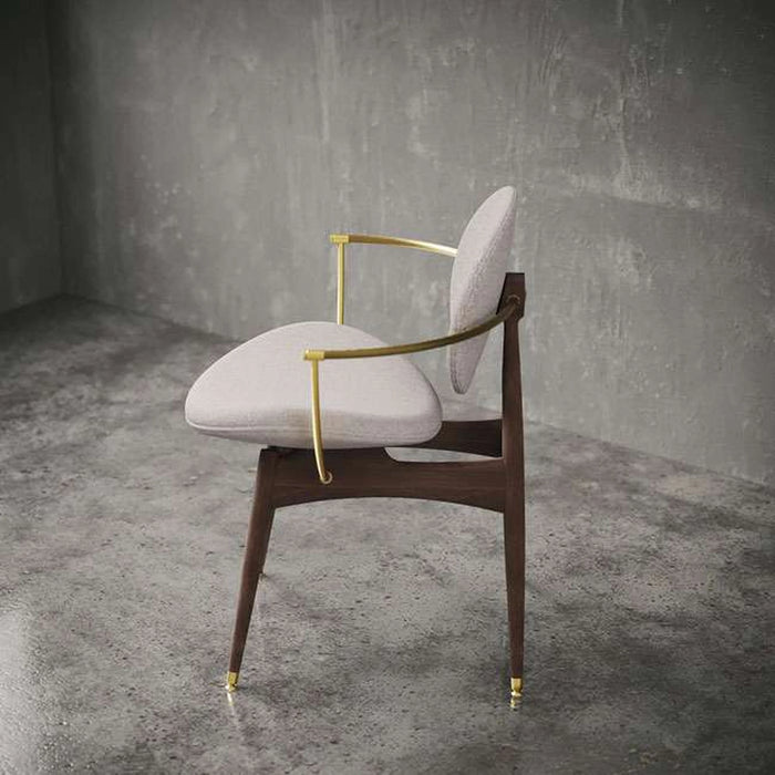 Modern chair with wooden frame and gold accents in a gray room