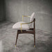 Modern chair with wooden frame and gold accents in a gray room