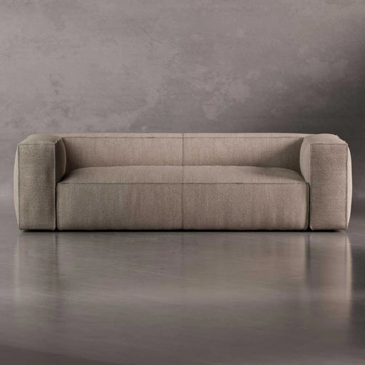 Beige sofa against a gray concrete wall