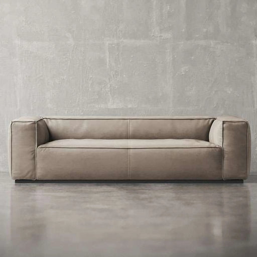 Beige sofa against a gray concrete wall