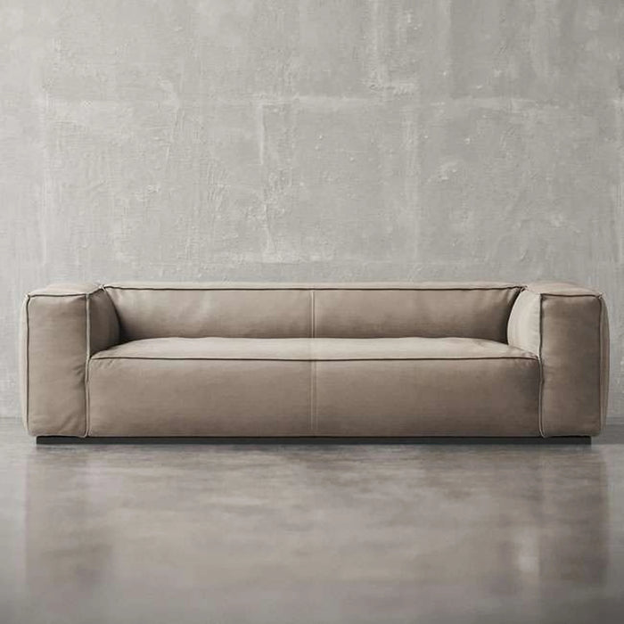 Beige sofa against a gray concrete wall