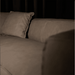 Brown sofa with a pillow against a dark background