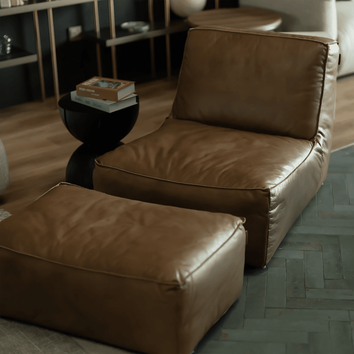 Brown leather sofa with ottoman in a living room setting