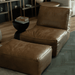 Brown leather sofa with ottoman in a living room setting