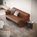 Brown leather sofa with patterned cushions in a modern living room.