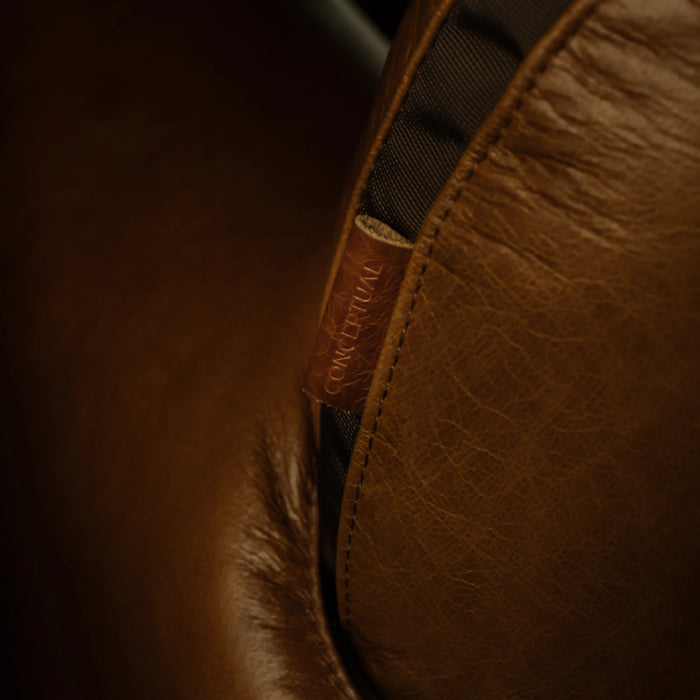 Close-up of a brown leather bag with a visible brand label.