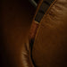 Close-up of a brown leather bag with a visible brand label.