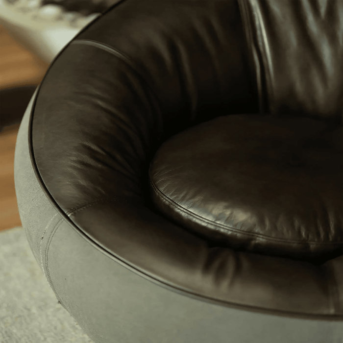 Close-up of a brown leather armchair with a blurred background