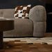 Brown textured sofa with a checkered pillow on a patterned rug