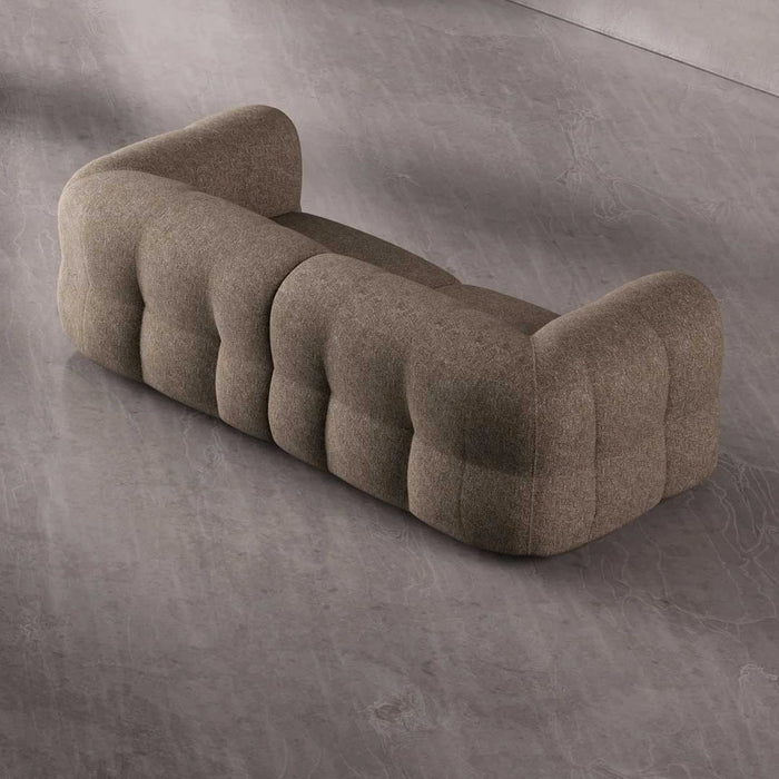 Brown tufted sofa on a gray concrete floor
