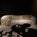 White sofa with patterned throw and pillow in a dimly lit room.