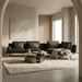 Modern living room with a gray sectional sofa, round coffee table, and abstract art on the wall.
