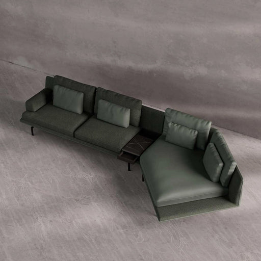 Green sectional sofa on a gray floor with a neutral wall background