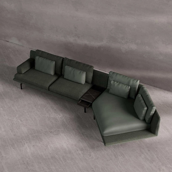 Green sectional sofa on a gray floor with a neutral wall background
