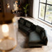 Modern living room with a gray sectional sofa, large window, and decorative elements.