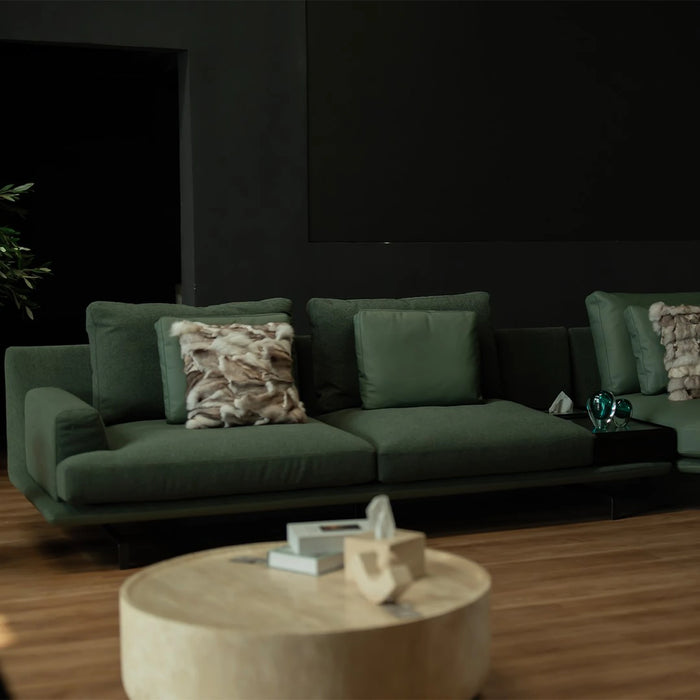 Green sofa with decorative pillows in a dimly lit room