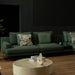 Green sofa with decorative pillows in a dimly lit room