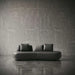 Modern black sofa against a textured gray wall