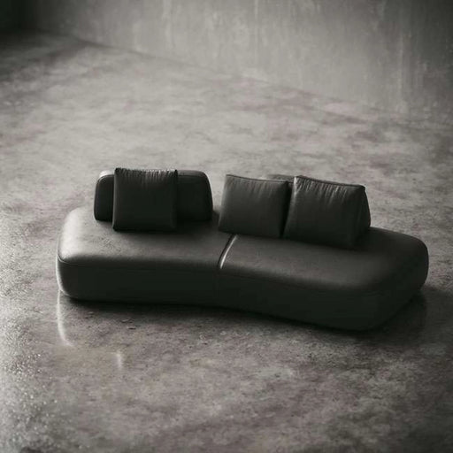 Modern black leather sofa on a concrete floor