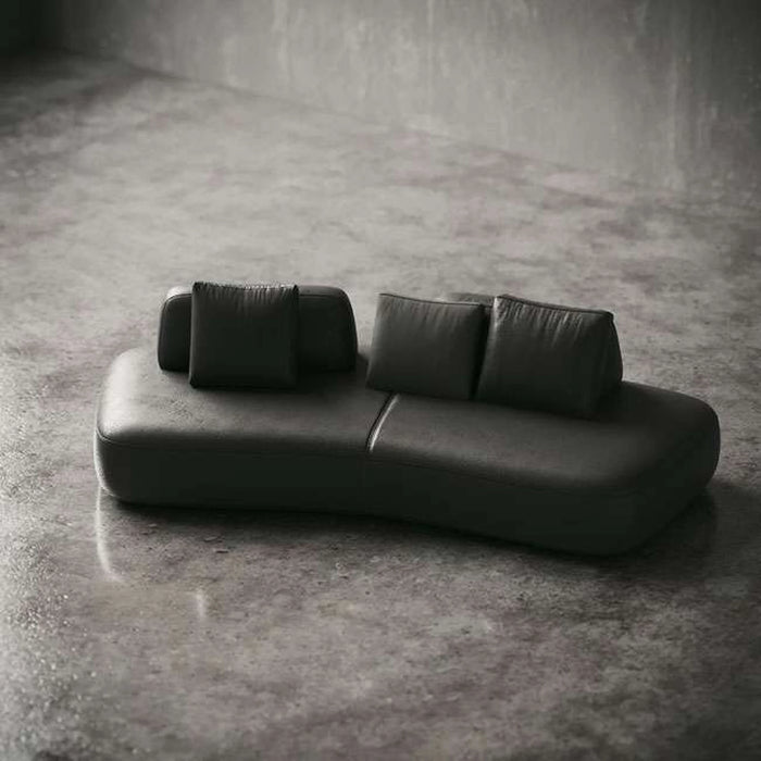 Modern black leather sofa on a concrete floor