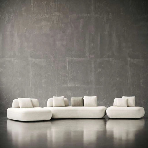 Modern white sofa against a textured gray wall