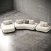 Modern white sofa with gray cushions on a concrete floor.