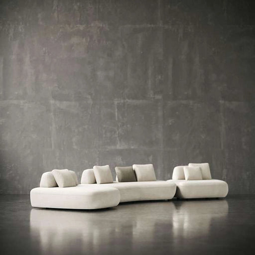 Modern white sofa against a textured gray wall
