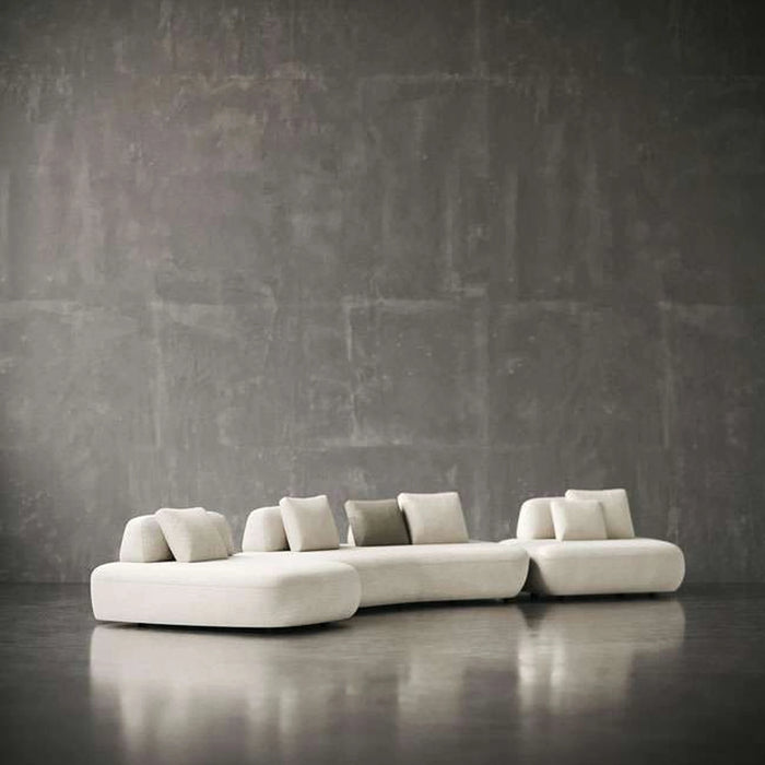 Modern white sofa against a textured gray wall