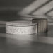 Two round tables, one with a terrazzo pattern and the other with a wooden finish, on a transparent background.