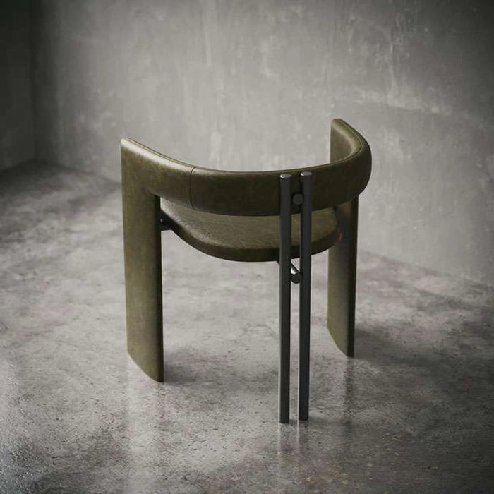 Modern chair with curved design and metal legs on a concrete floor.