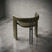 Modern chair with curved design and metal legs on a concrete floor.