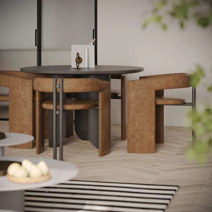 Dining area with a round wooden table and chairs on a wooden floor.