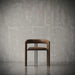 Wooden chair against a gray concrete wall
