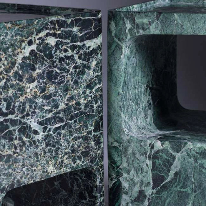 Close-up of green marble bathroom fixtures with intricate patterns.