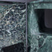 Close-up of green marble bathroom fixtures with intricate patterns.