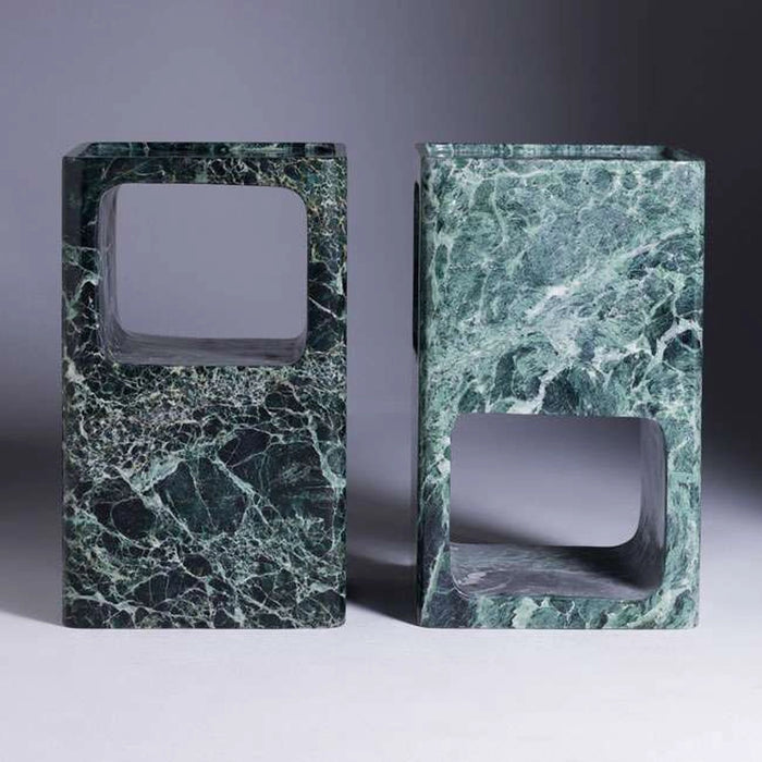 Two green marble bookends on a gray background