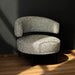Gray textured armchair on a wooden floor with a dark wall background