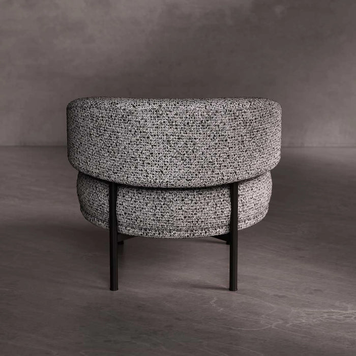 Round ottoman with textured gray upholstery on a dark gray background