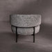 Round ottoman with textured gray upholstery on a dark gray background