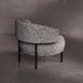 Round, gray textured chair with black legs on a gray floor and background