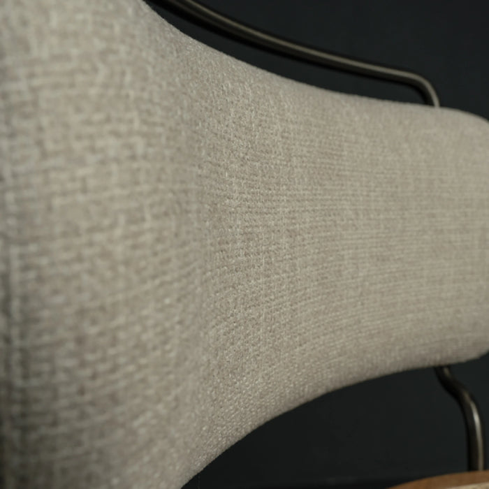 Close-up of a textured beige chair backrest on a dark background